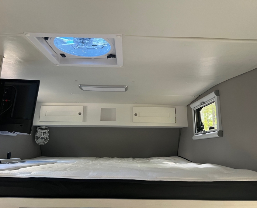 Tiger Panthera overhead bed with ceiling vent, storage cabinets, and TV