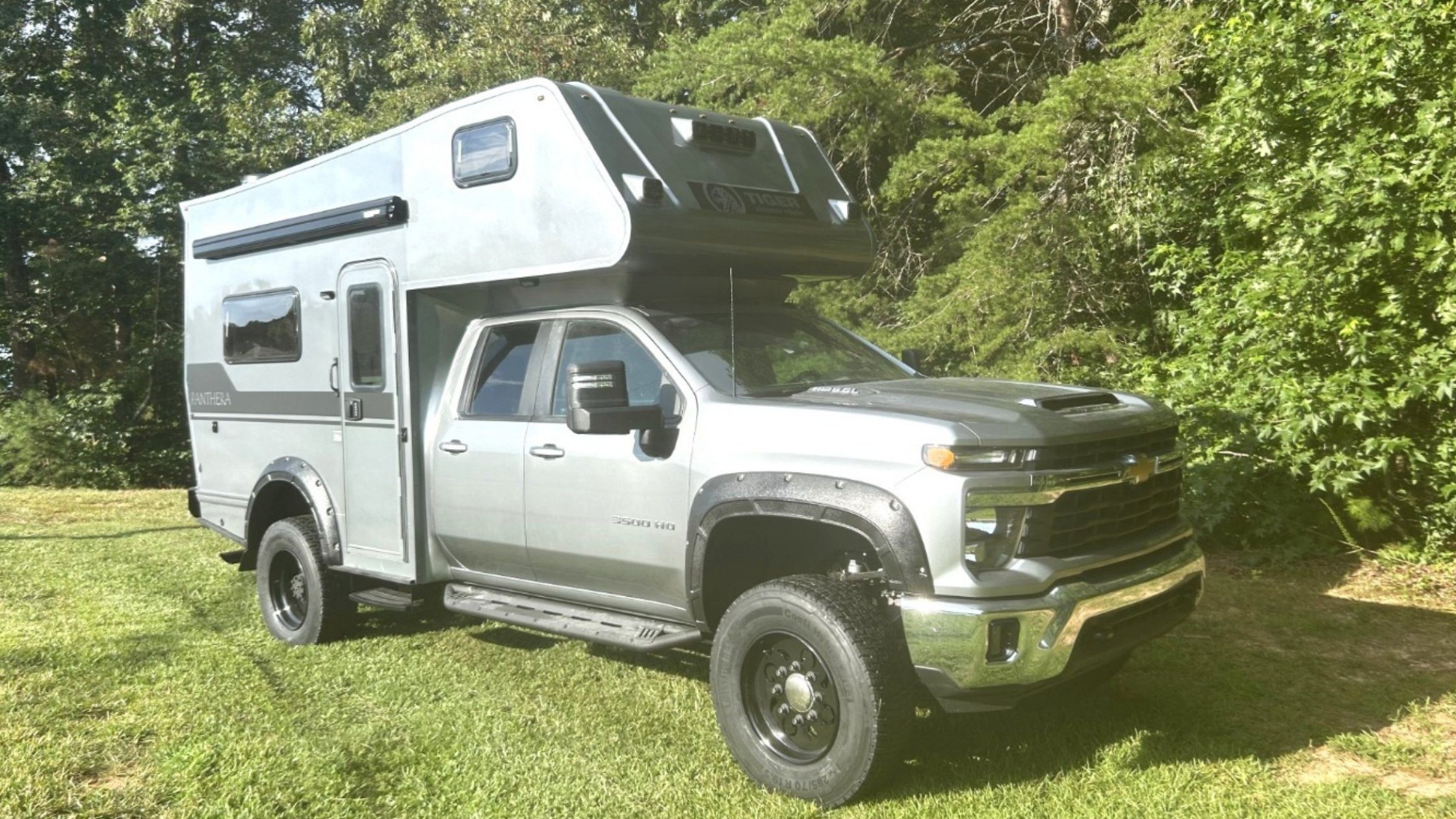 tiger-vehicles-2025-PANTHERAHD | Tiger Adventure Vehicles | Tiger Adventure Vehicles Tiger Panthera truck camper on Chevrolet chassis parked outdoors with trees